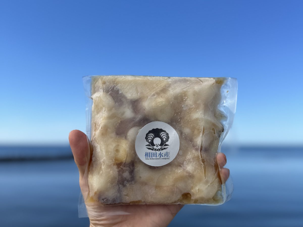 海を背景に商品を持つ手